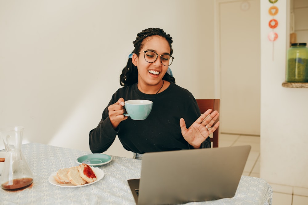 woman in black long sleeve shirt holding white ceramic mug