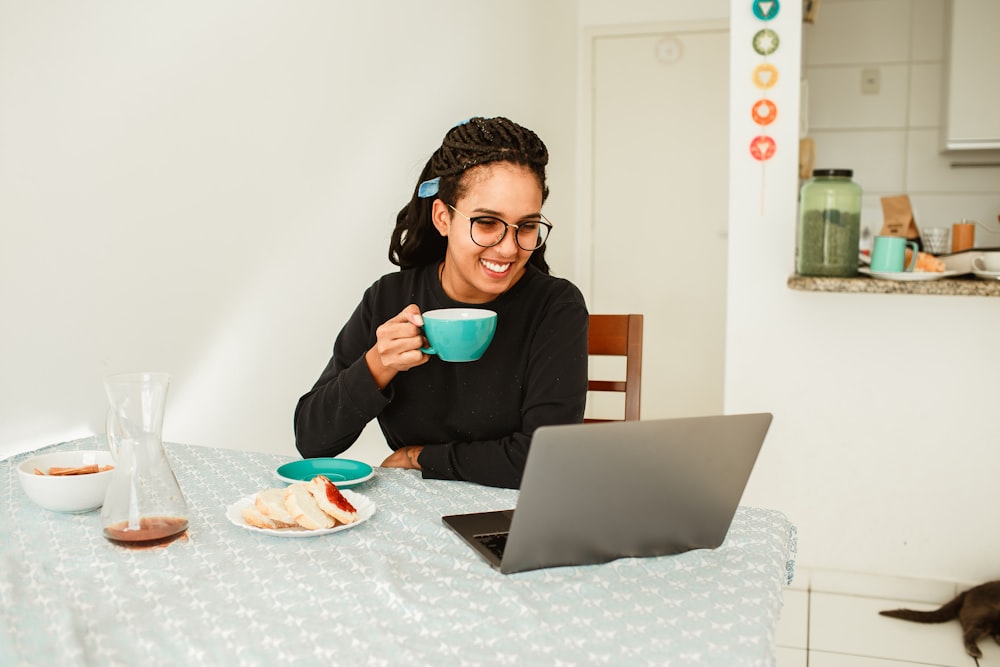 woman in black long sleeve shirt holding black ceramic mug