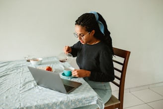 woman in black long sleeve shirt sitting on brown wooden chair