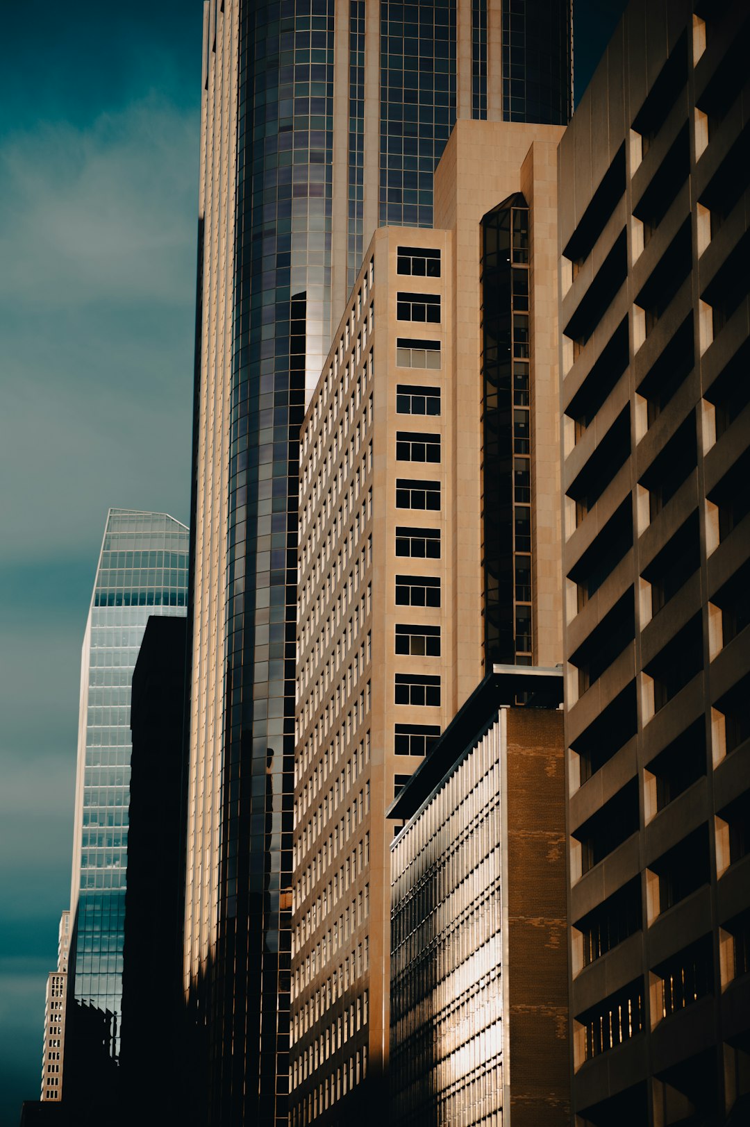 brown and white high rise buildings under white clouds during daytime