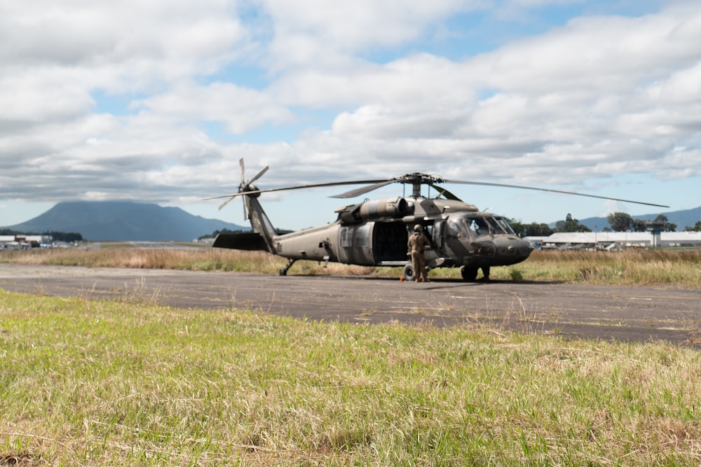 gray helicopter on green grass field during daytime