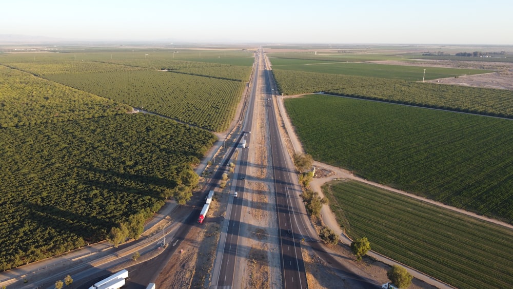 strada asfaltata grigia tra il campo di erba verde durante il giorno