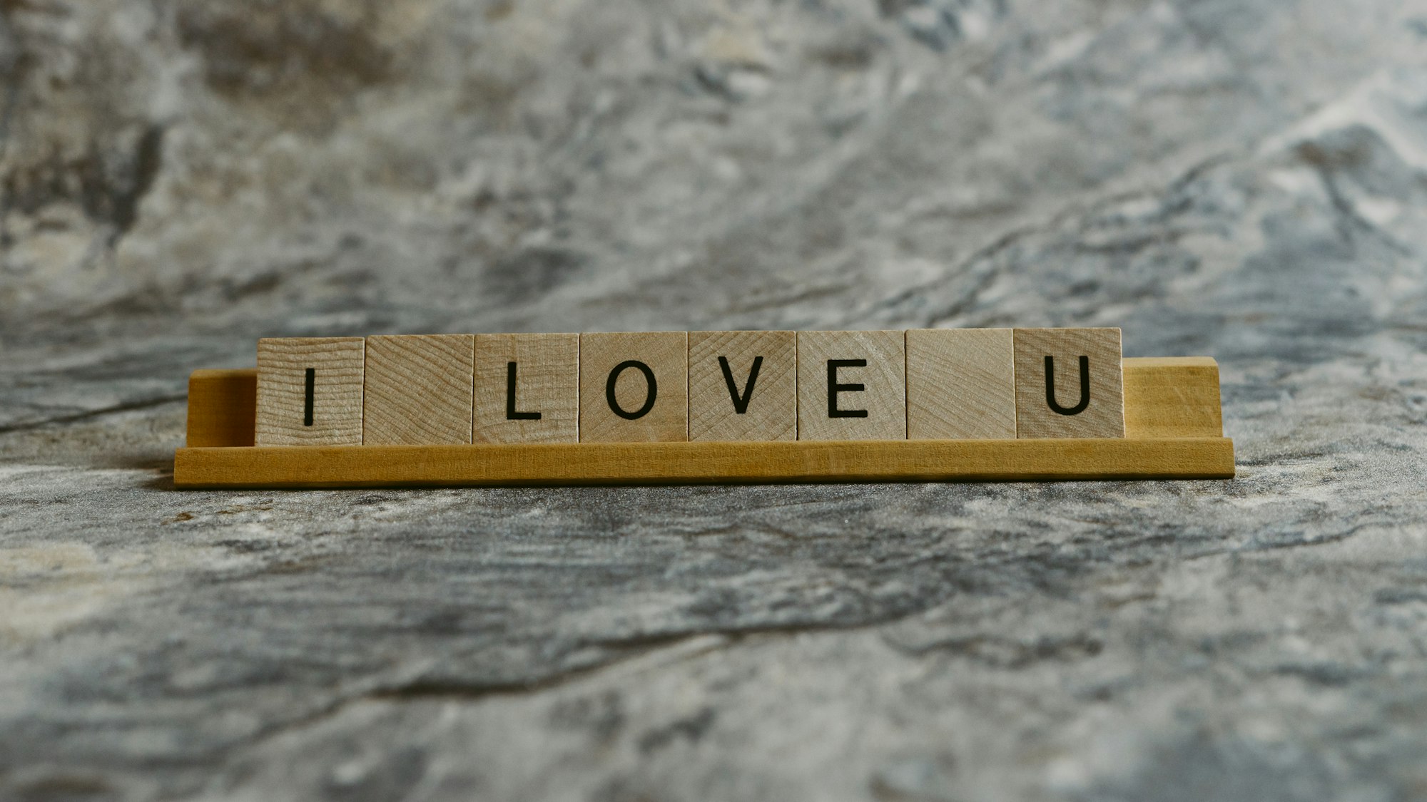 Square pieces with letters from a board game forming the phrase "I love you"