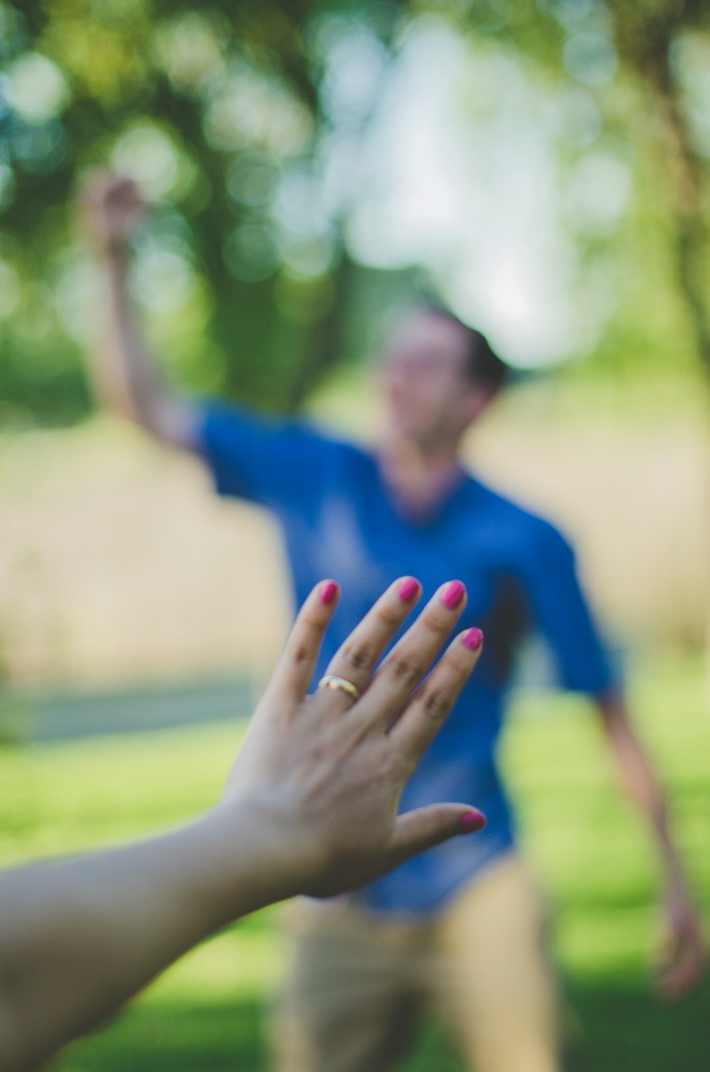 man in blue polo shirt raising his right hand