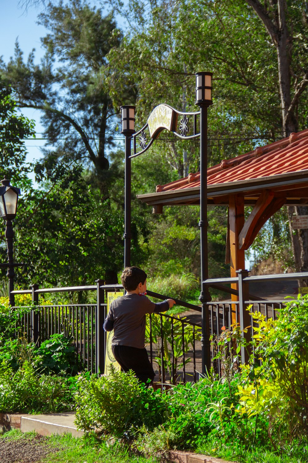 man in white t-shirt and black pants sitting on brown wooden swing bench