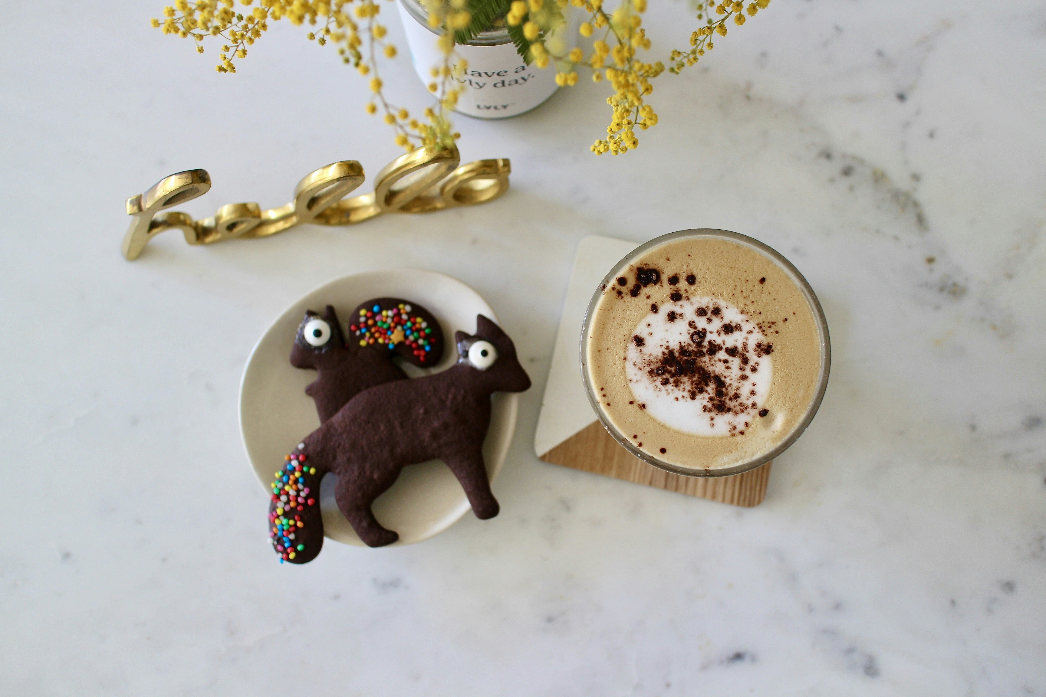 black and white cow ceramic figurine beside gold and gold beaded necklace