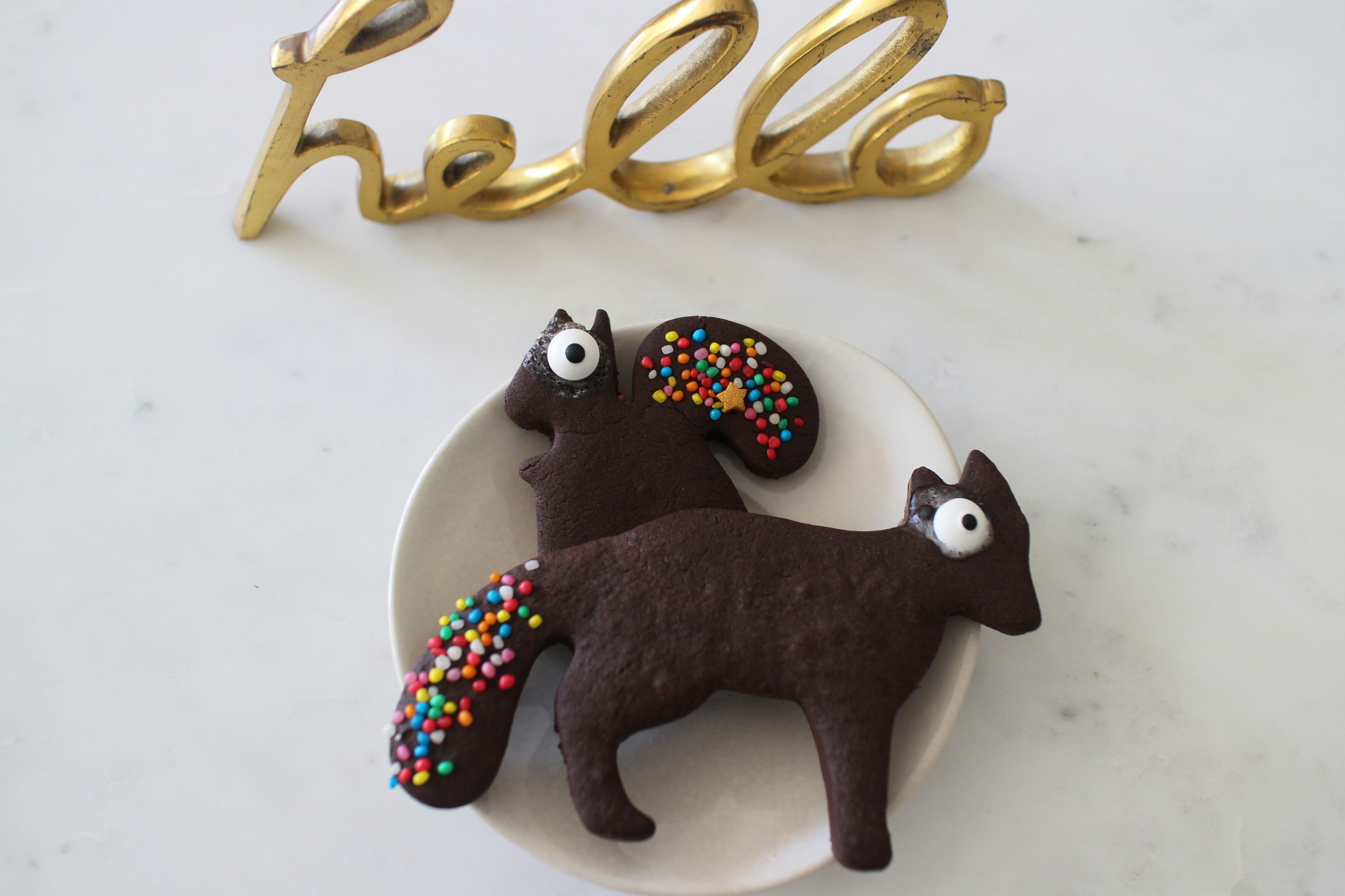 black and white cat figurine beside gold and blue beaded necklace