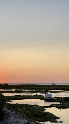 white boat on sea during sunset