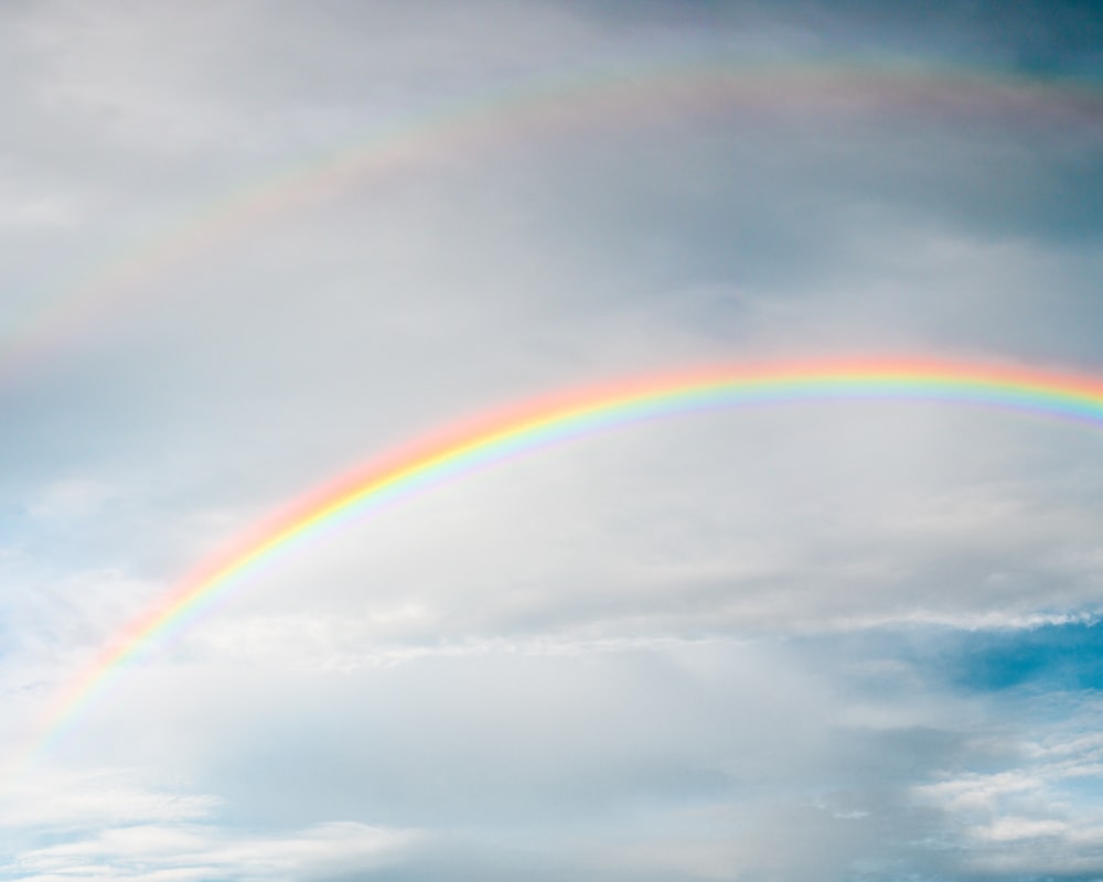 rainbow under cloudy sky during daytime