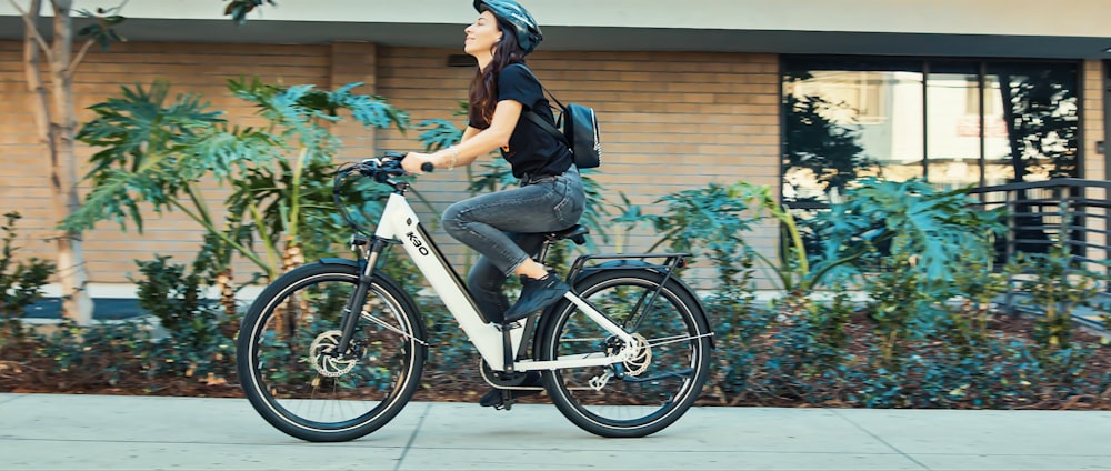 man in black t-shirt riding on white and black bicycle