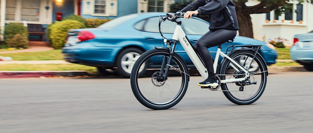 person in black jacket riding on blue bicycle during daytime