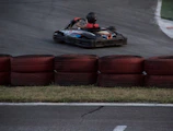 Close-up of a go-kart racer gripping the steering wheel, intense focus visible.