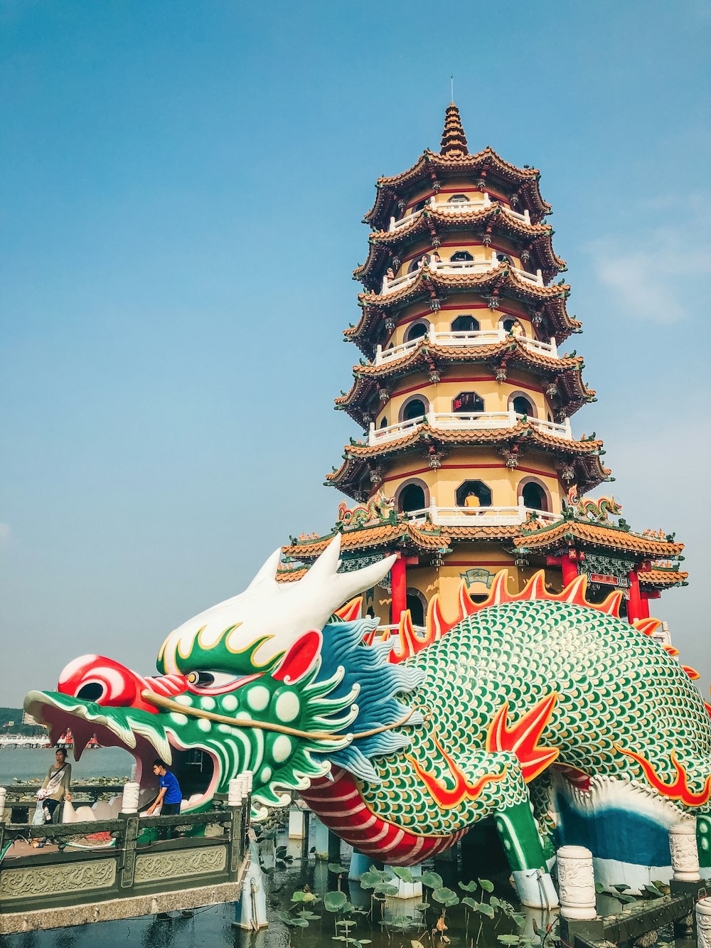 a tall tower with a dragon statue in front of it