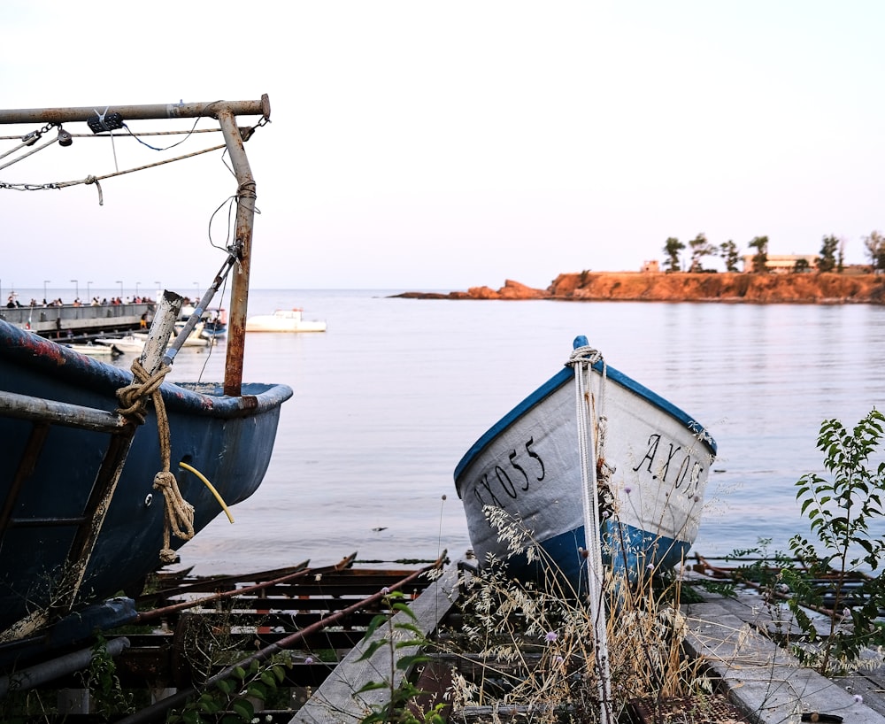 white and blue boat on sea shore during daytime