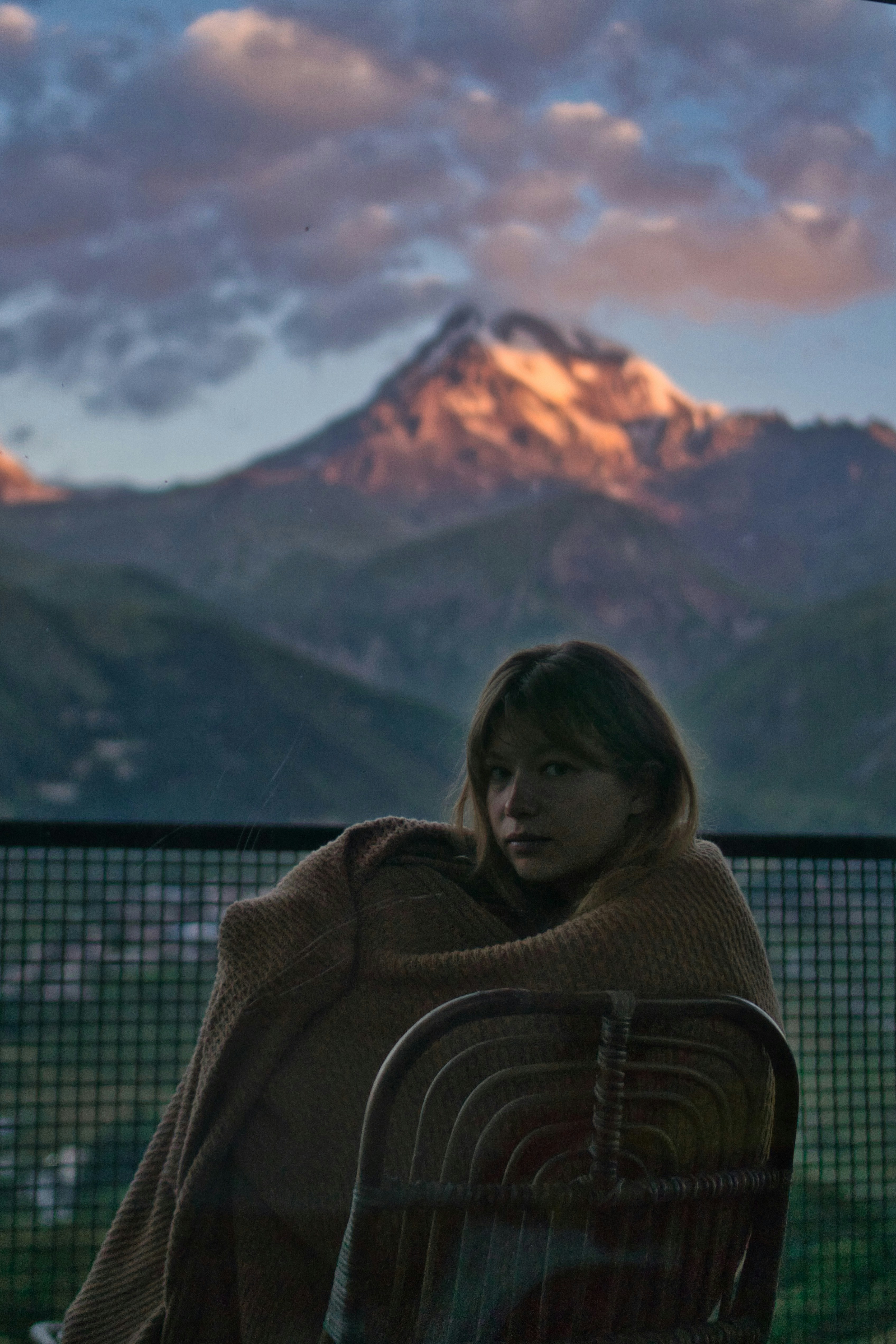 woman in brown hoodie sitting on brown wooden bench