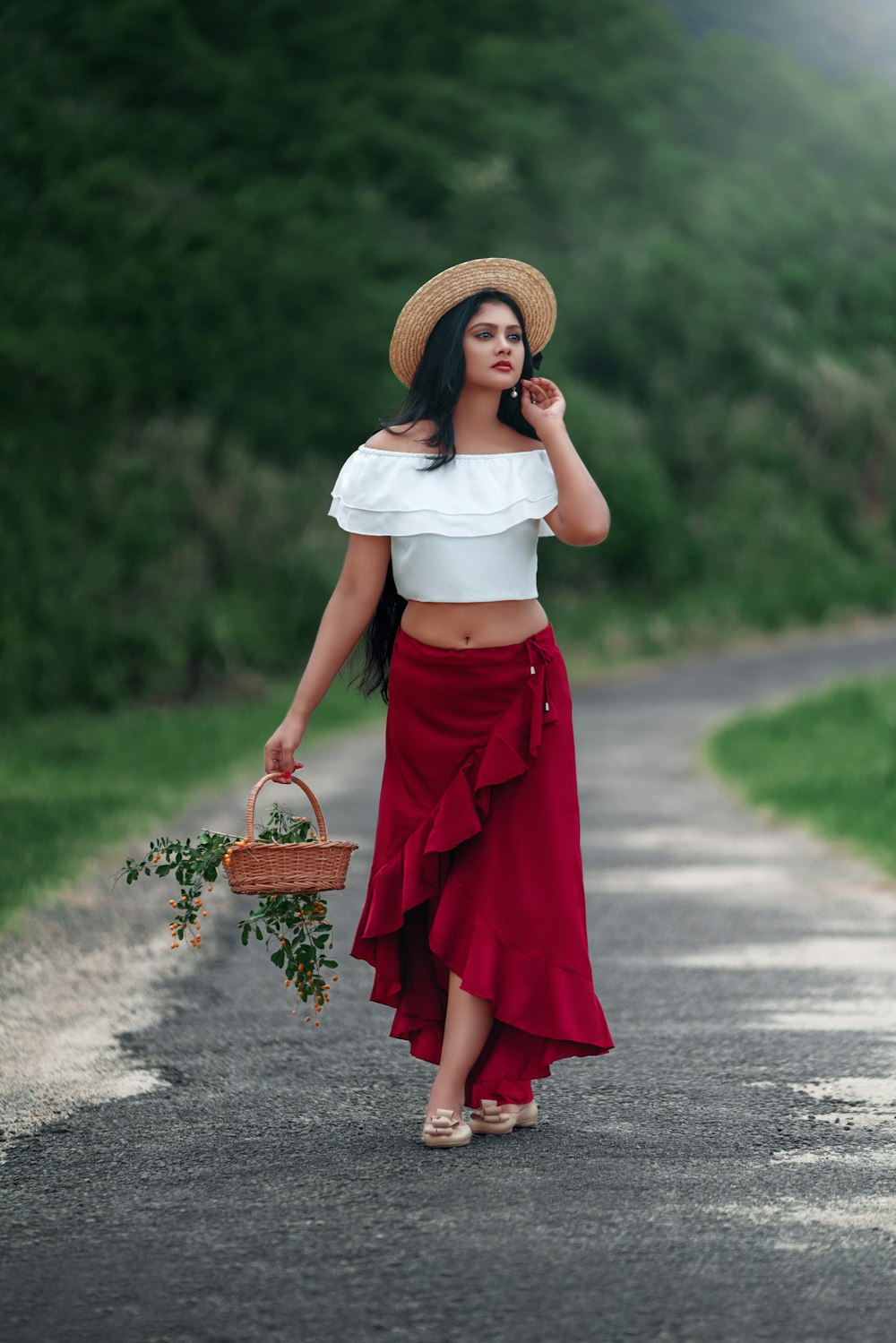 woman in white shirt and red skirt holding brown woven basket