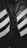 Close-up shot of a pair of classic black and white athletic shoes with the word 'SAMBA' written on one. The shoes feature distinctive white stripes and black laces on a leather surface, highlighting their iconic design.