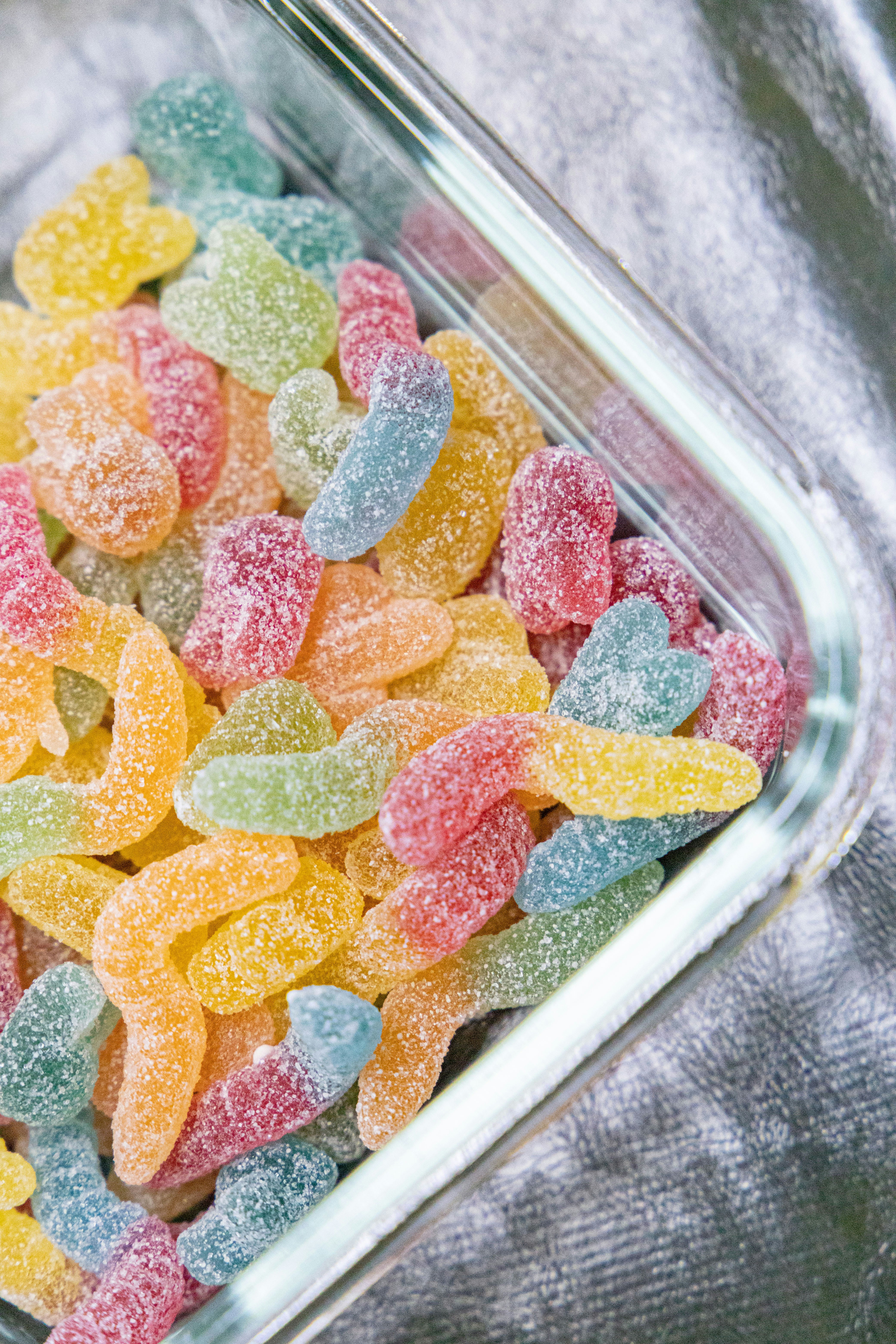 Pink blue and yellow candies in clear plastic container photo Free