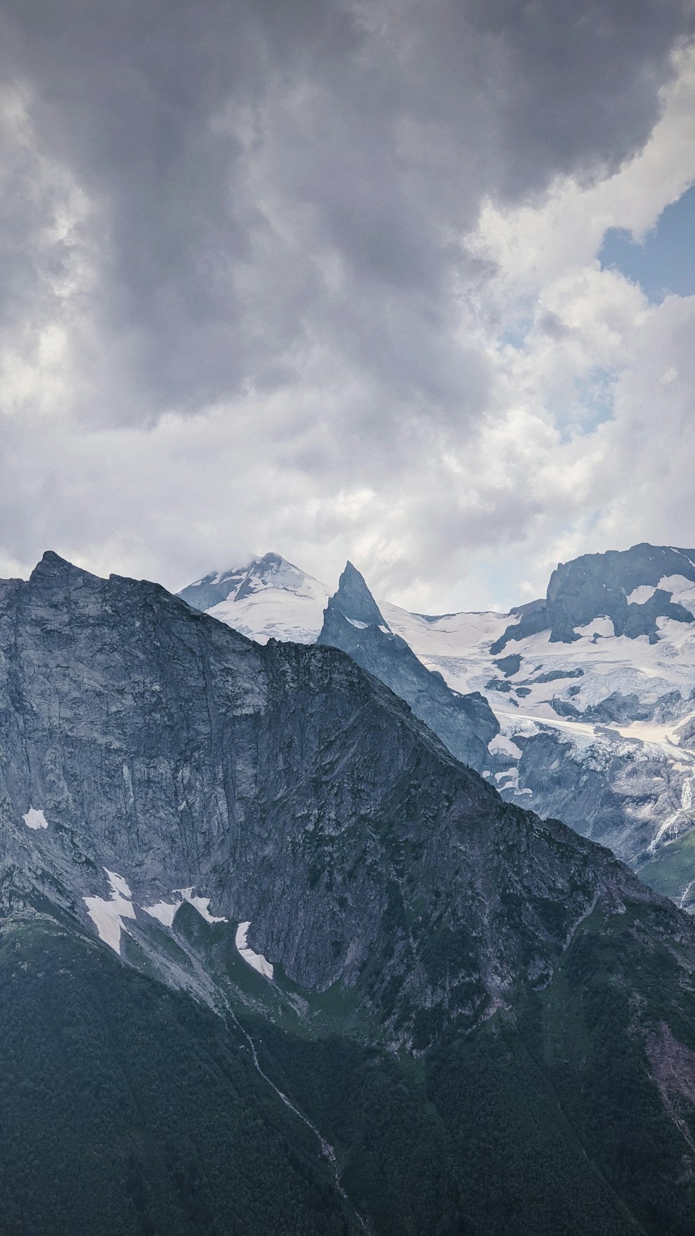 snow covered mountain under cloudy sky during daytime