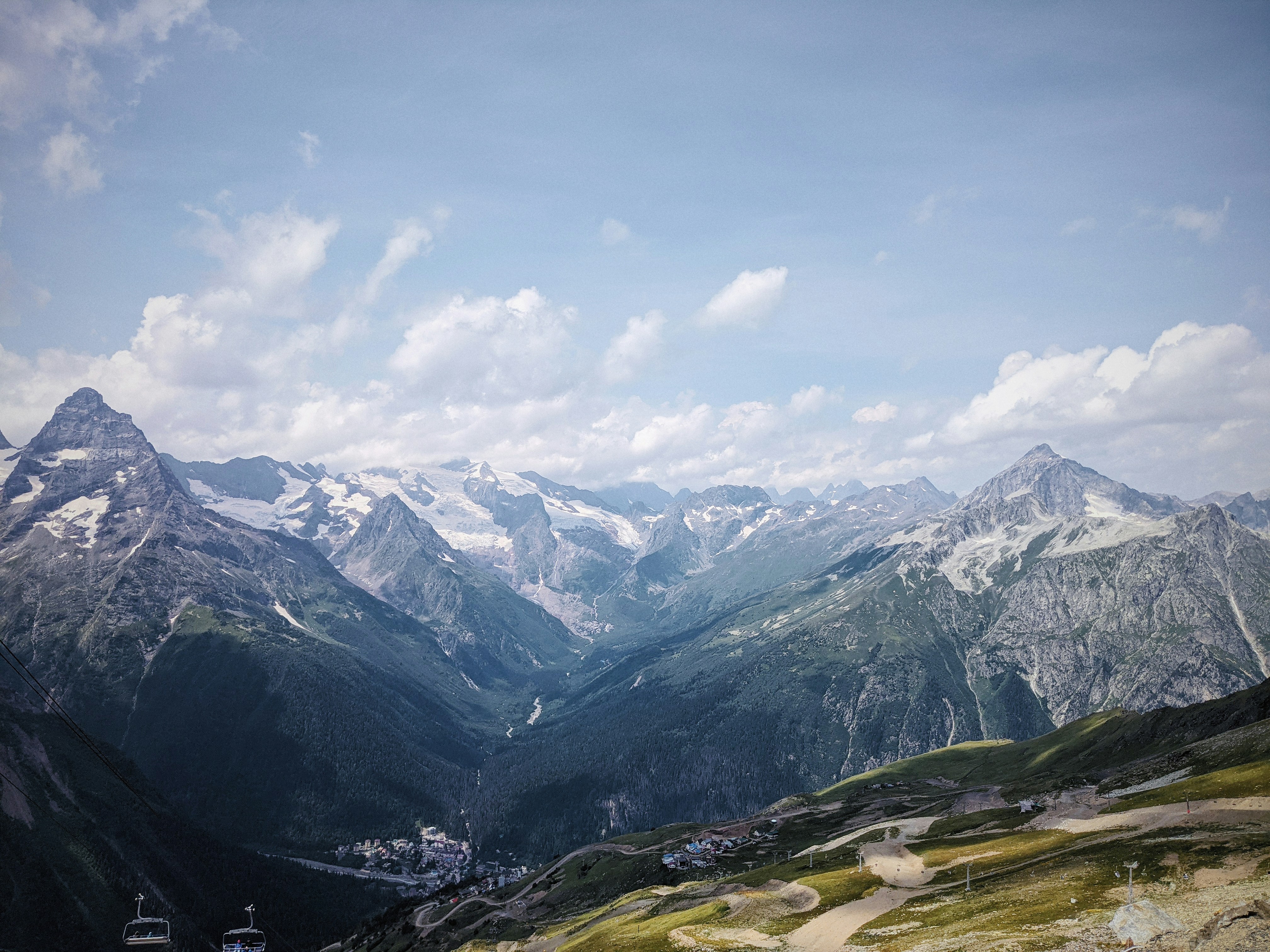 green grass field and mountains under white clouds and blue sky during daytime realistic teams background