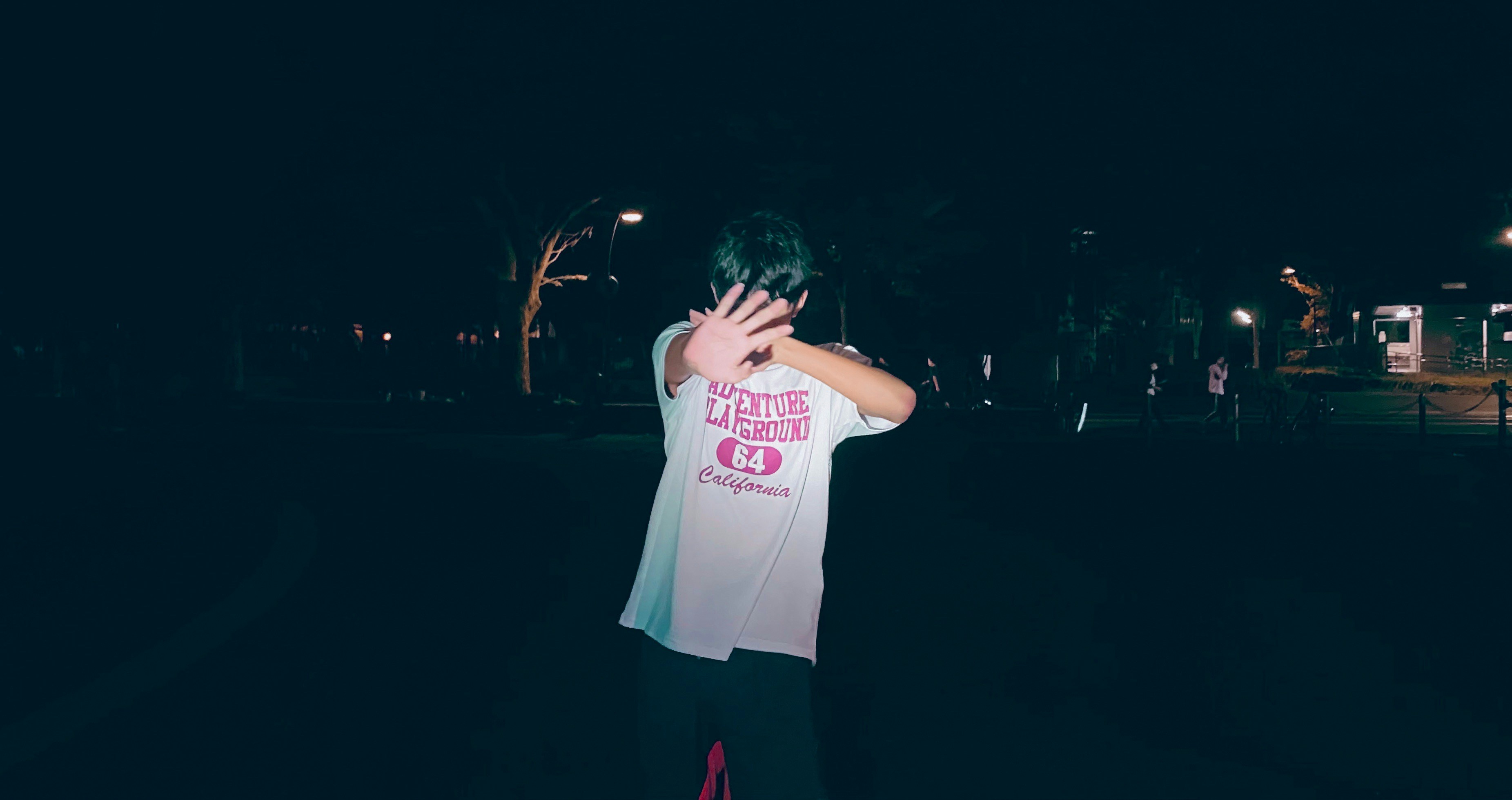 man in white crew neck t-shirt and red shorts standing during nighttime