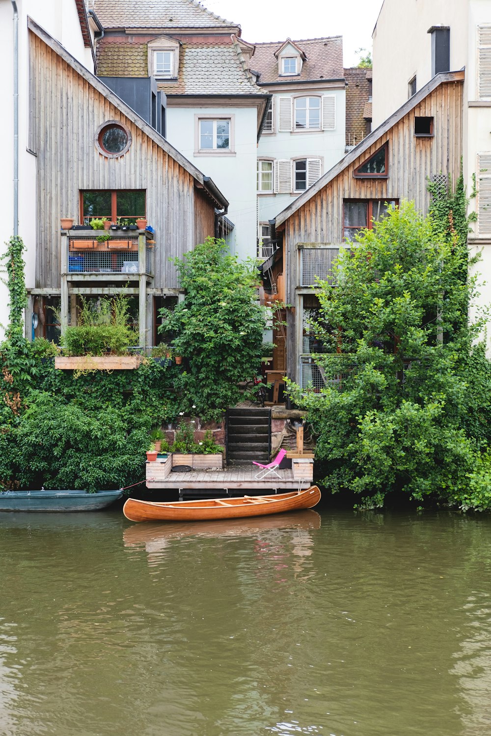 brown wooden boat on river near green trees during daytime