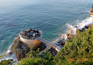 people walking on gray concrete bridge over blue sea during daytime