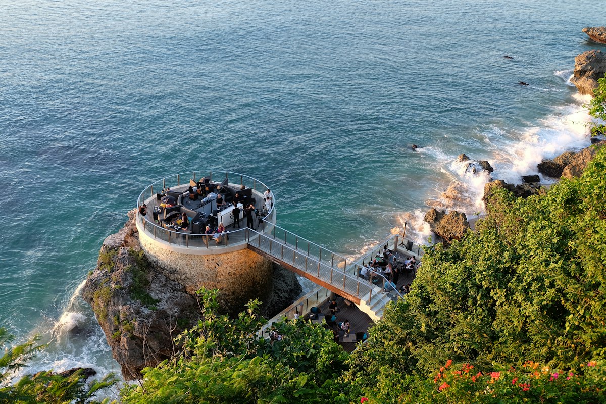 Guests on a cliffside path above the Indian Ocean near a Bali beach resort
