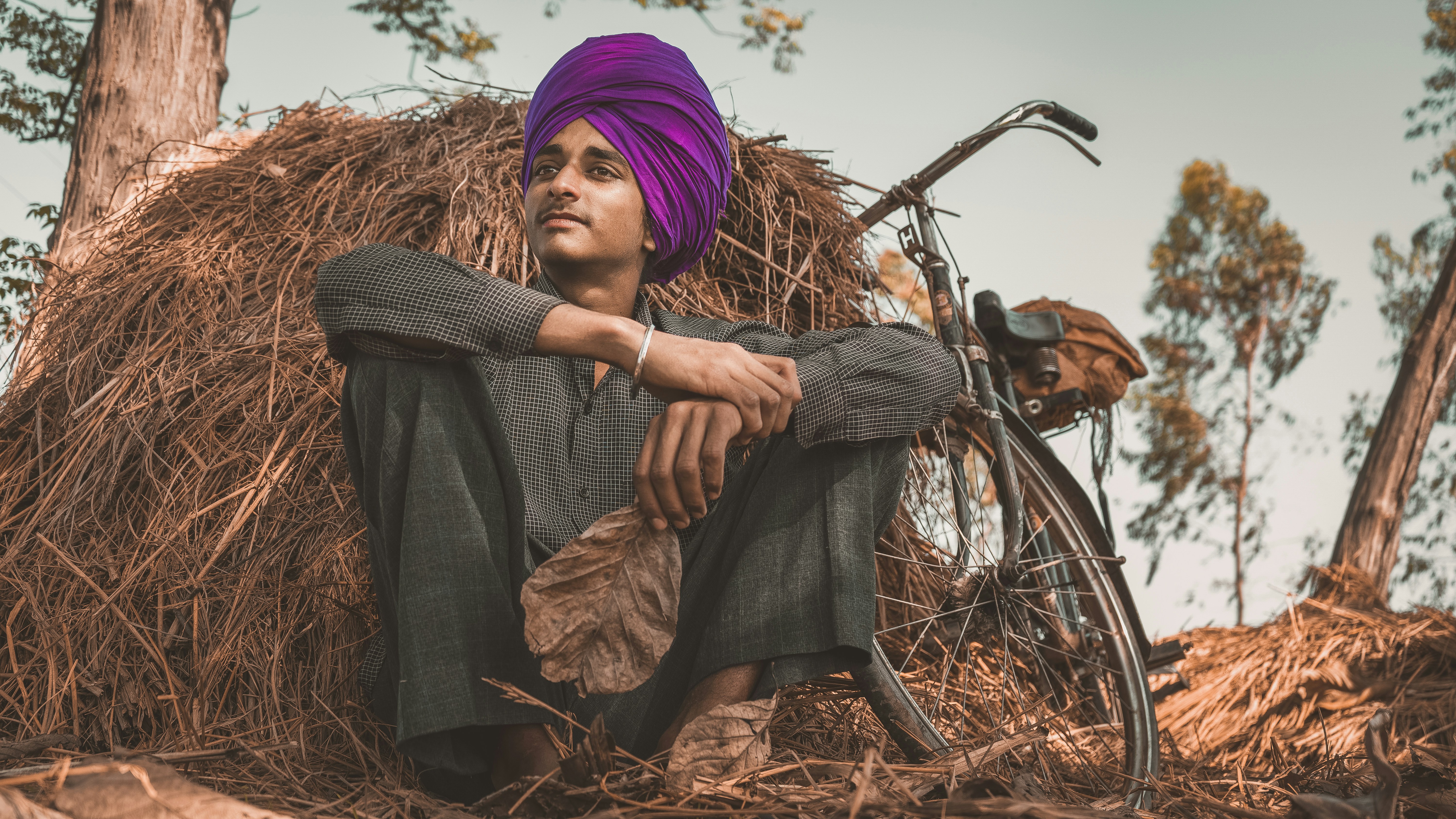woman in purple hijab and brown dress holding bicycle