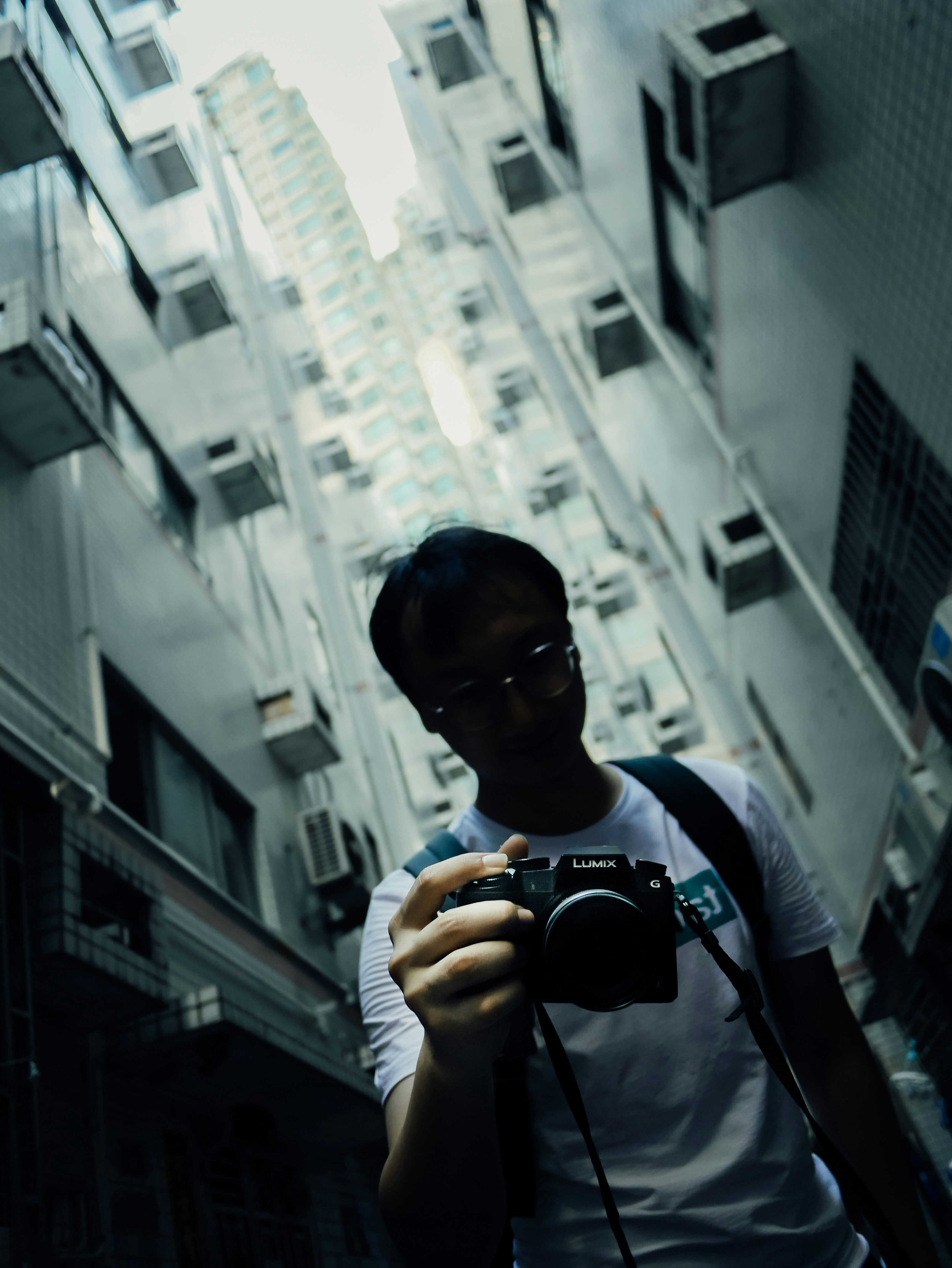 man in black and white crew neck t-shirt holding black dslr camera