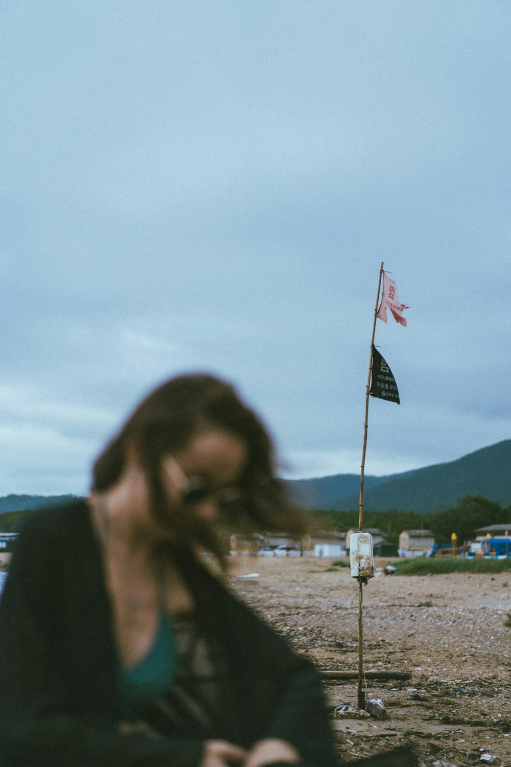 woman in black coat standing near flag of america during daytime