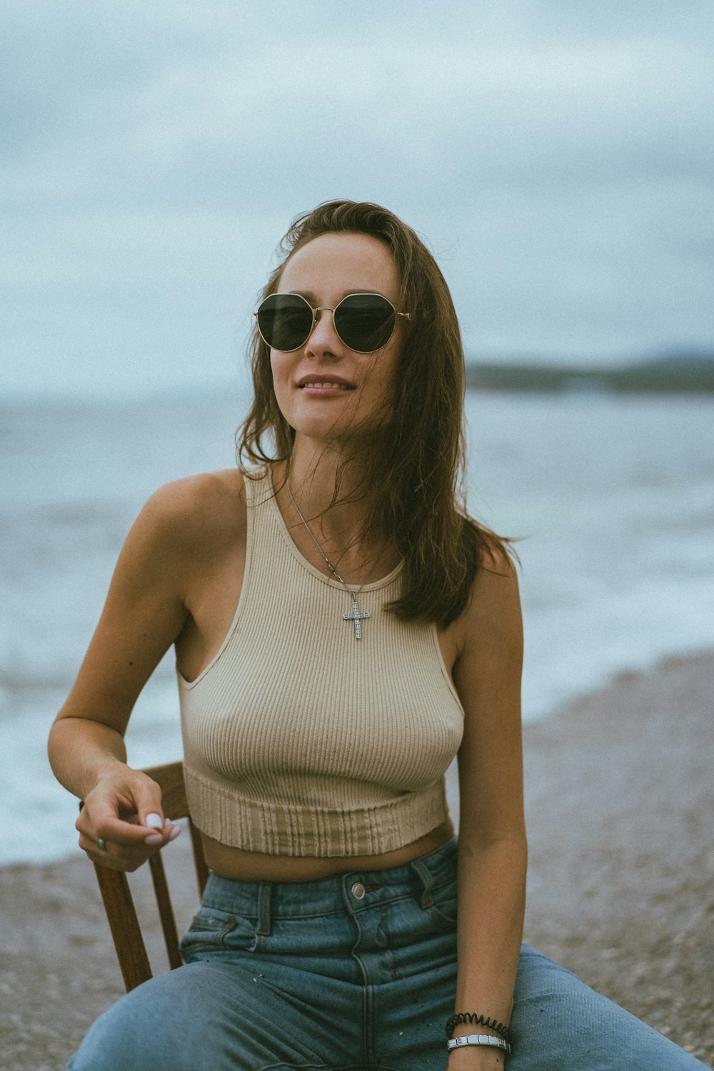 Frau in weißem Tanktop mit Sonnenbrille tagsüber am Strand