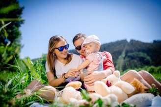 woman in white shirt carrying baby in white and red stripe shirt