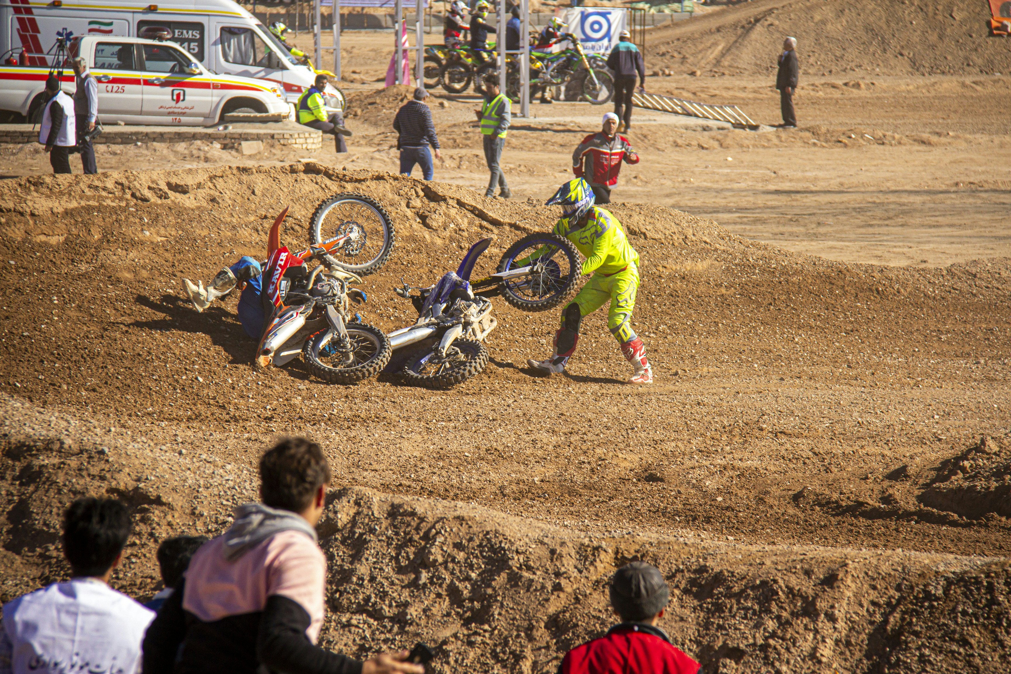 girl in red jacket and green pants riding motocross dirt bike