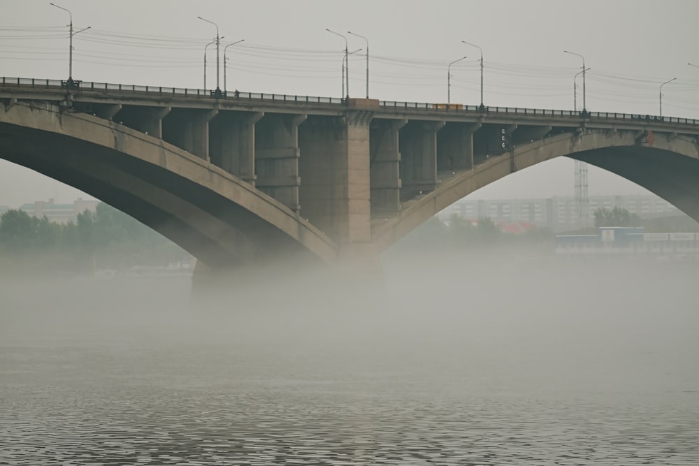 ponte de concreto cinza sobre o corpo de água durante o dia