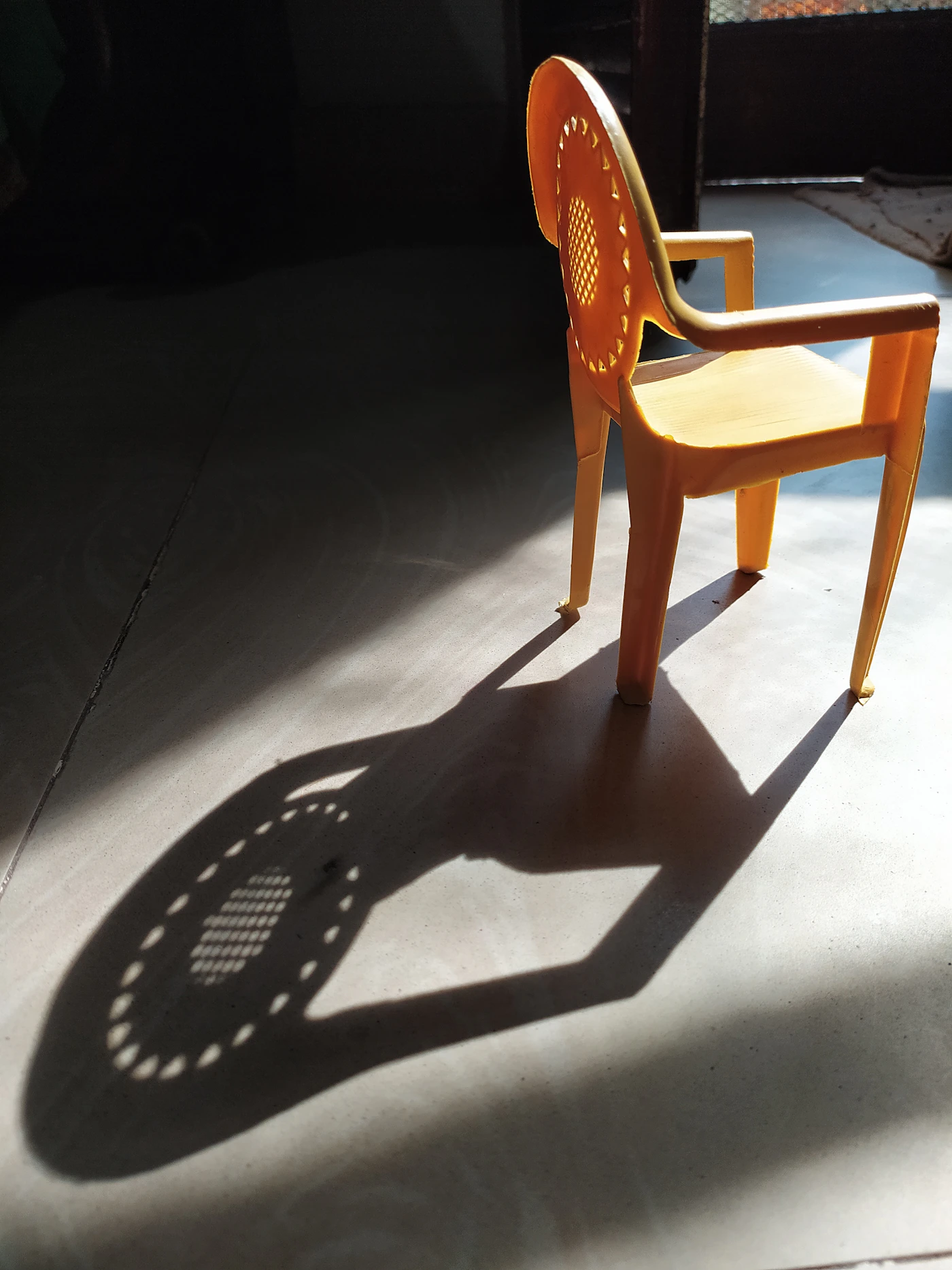 An empty chair casting a long shadow, representing a safe space for reflection