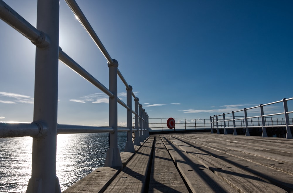 brown wooden dock on sea under blue sky during daytime