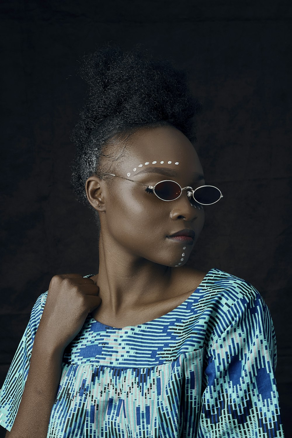 Femme en chemise rayée bleue et blanche portant des lunettes de soleil