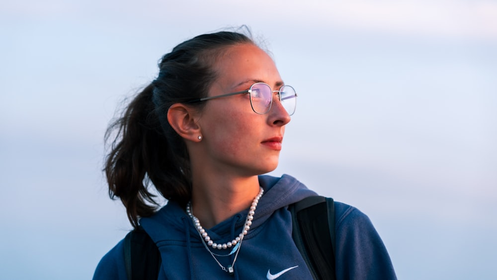 woman in blue zip up jacket wearing eyeglasses