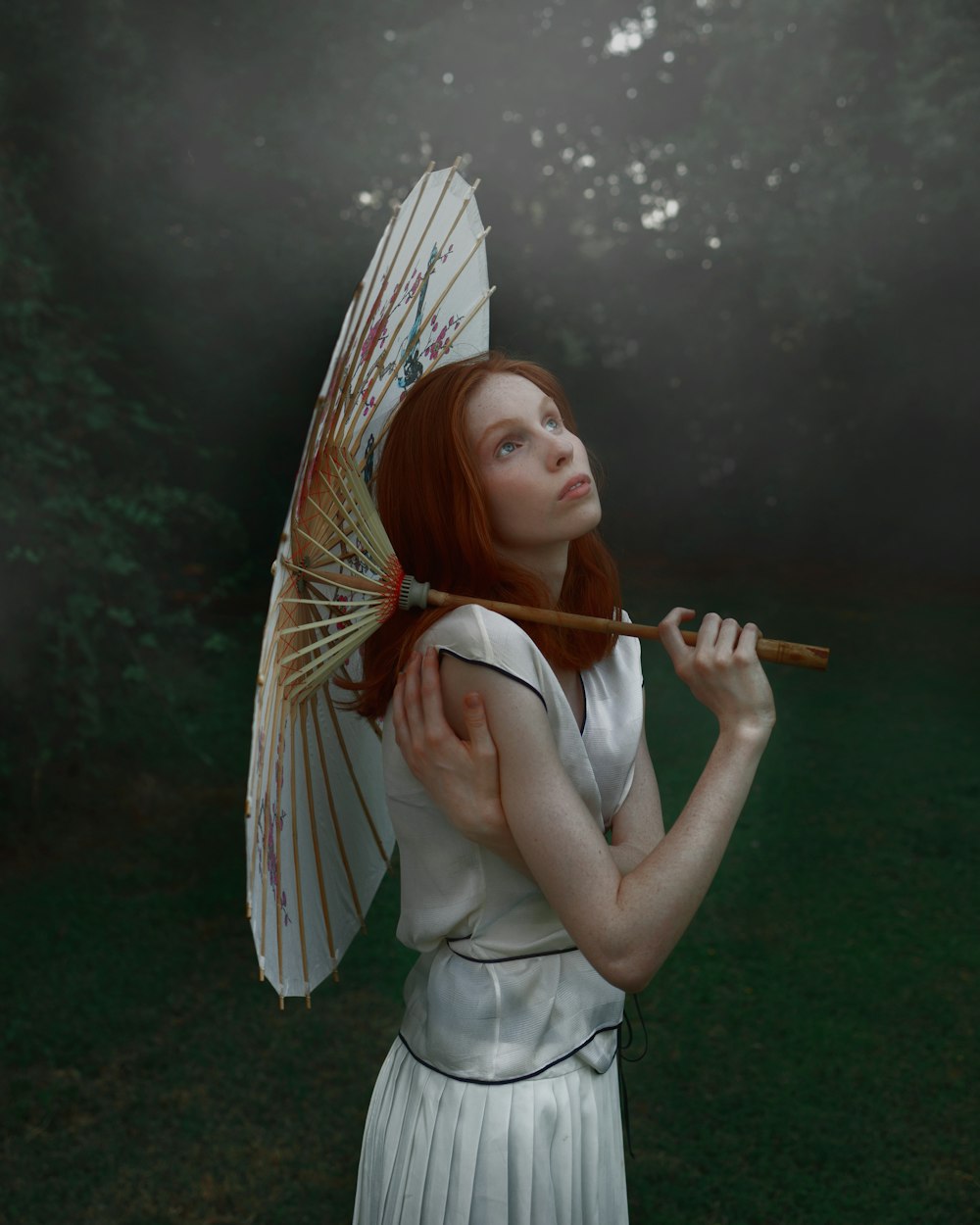 woman in white dress holding brown and white umbrella
