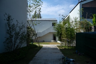 white concrete house near green trees under blue sky during daytime