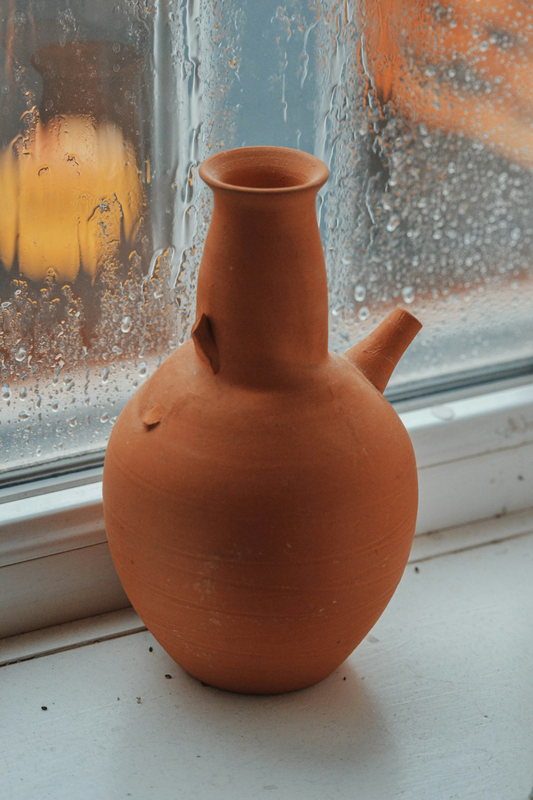 brown clay vase on window