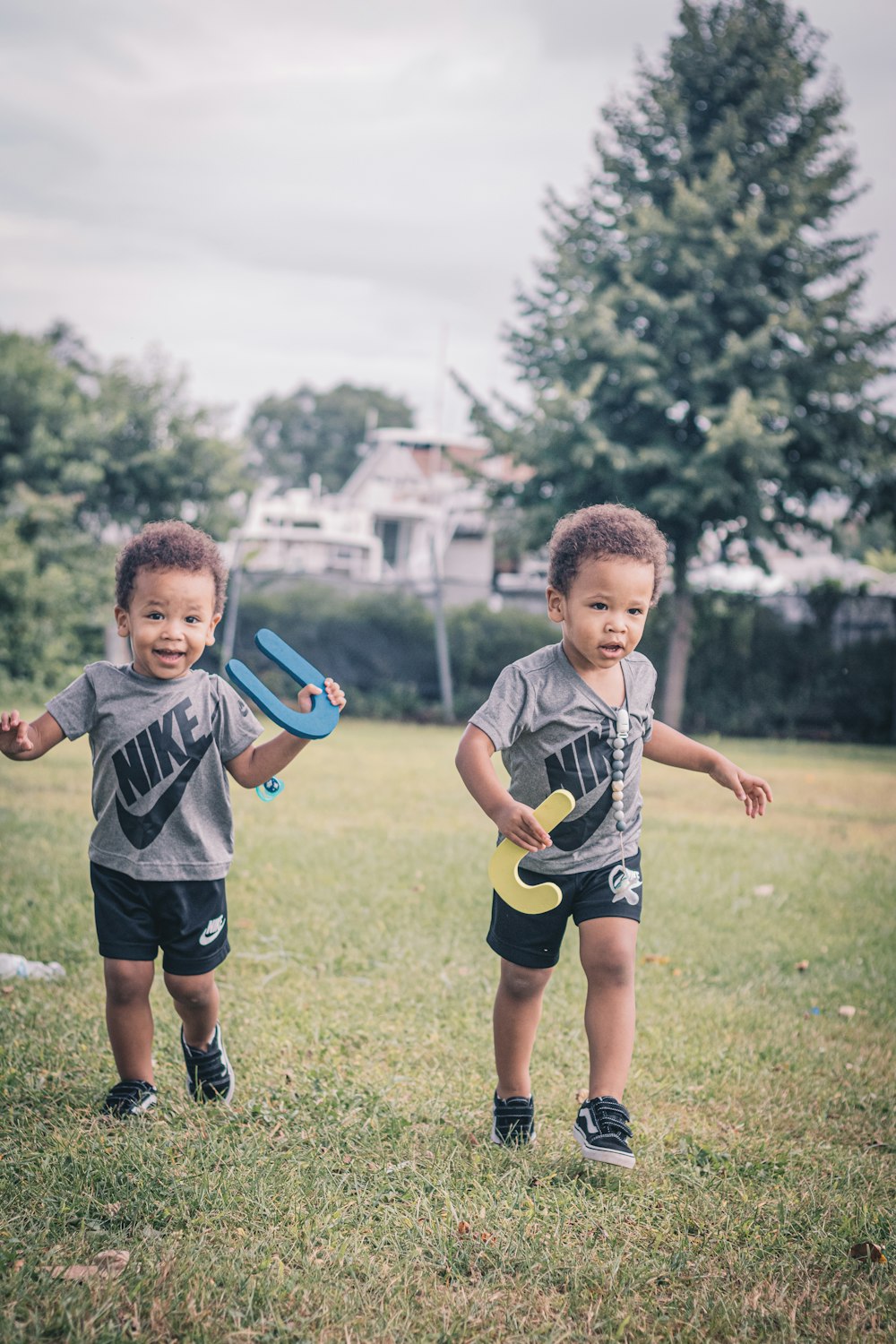 boy in gray crew neck t-shirt and black shorts holding green orange and blue plastic