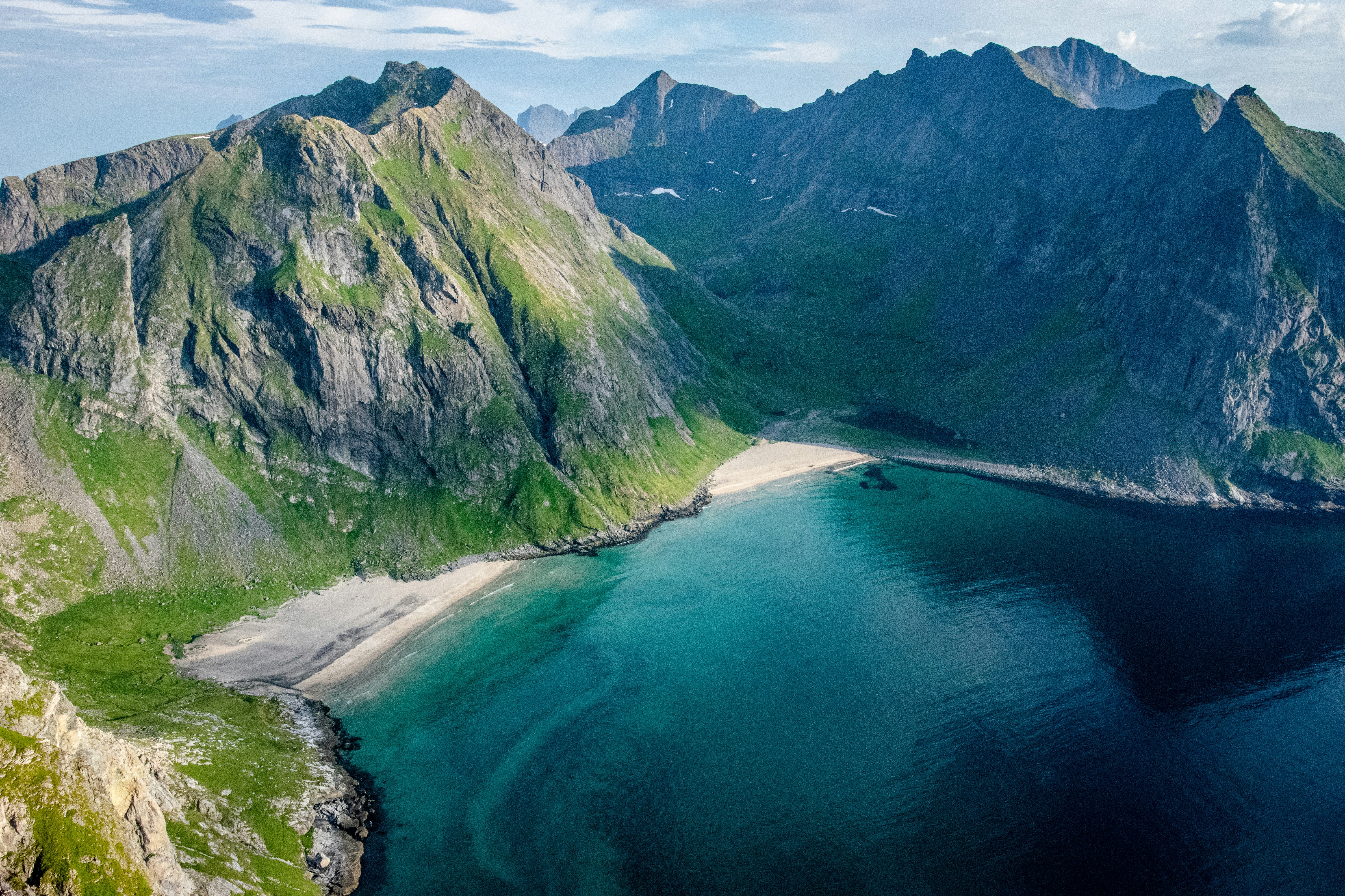 green and gray mountains beside body of water during daytime