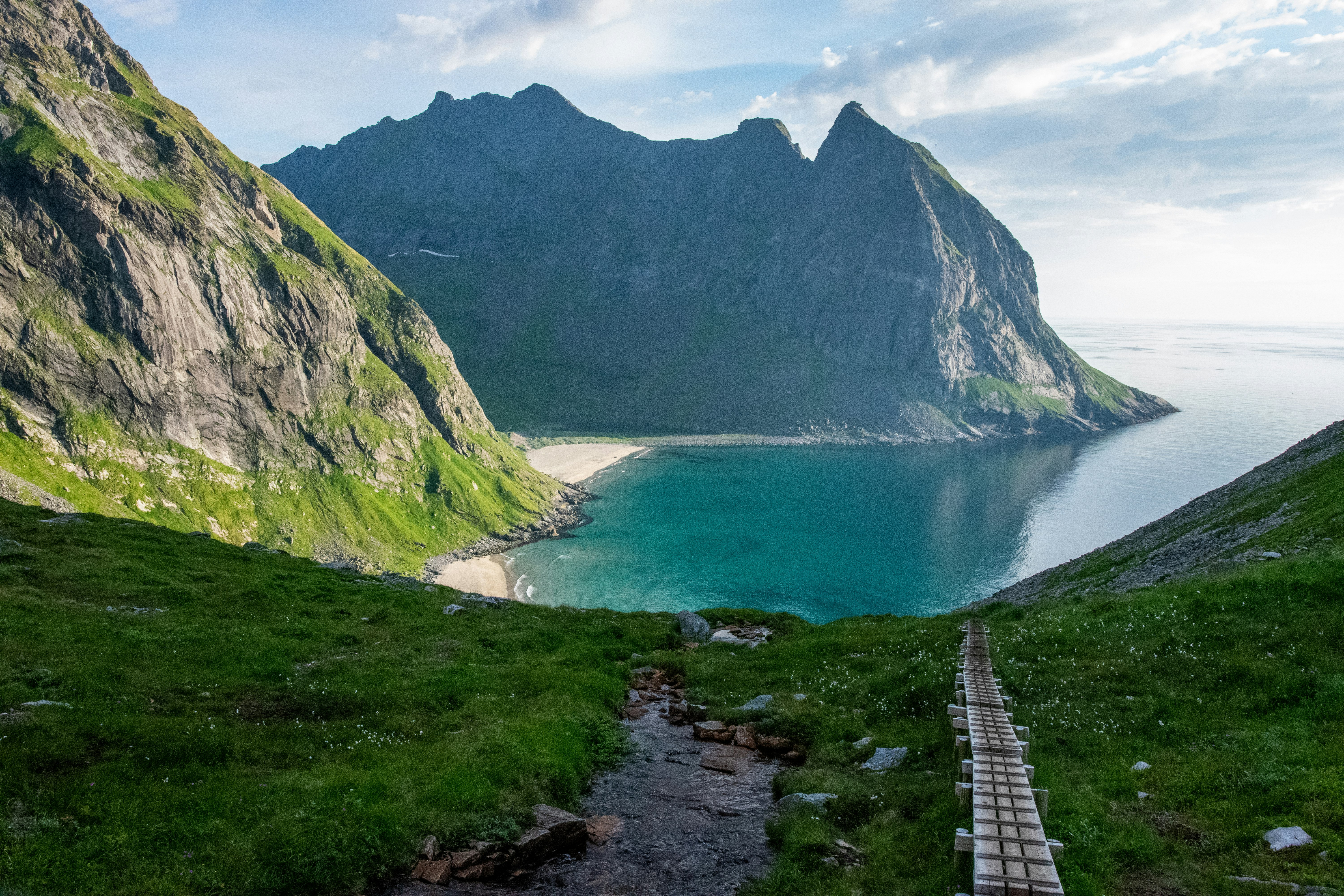 green and brown mountain beside body of water during daytime