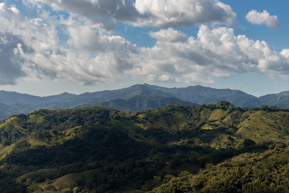 green and brown mountains under white clouds and blue sky during daytime