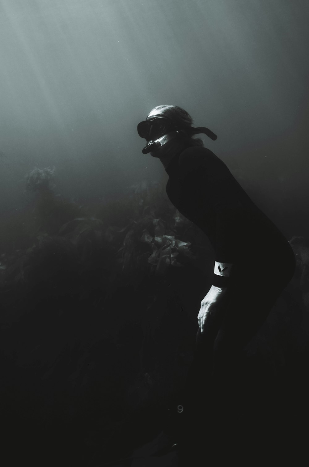 man in black shorts and black goggles in water