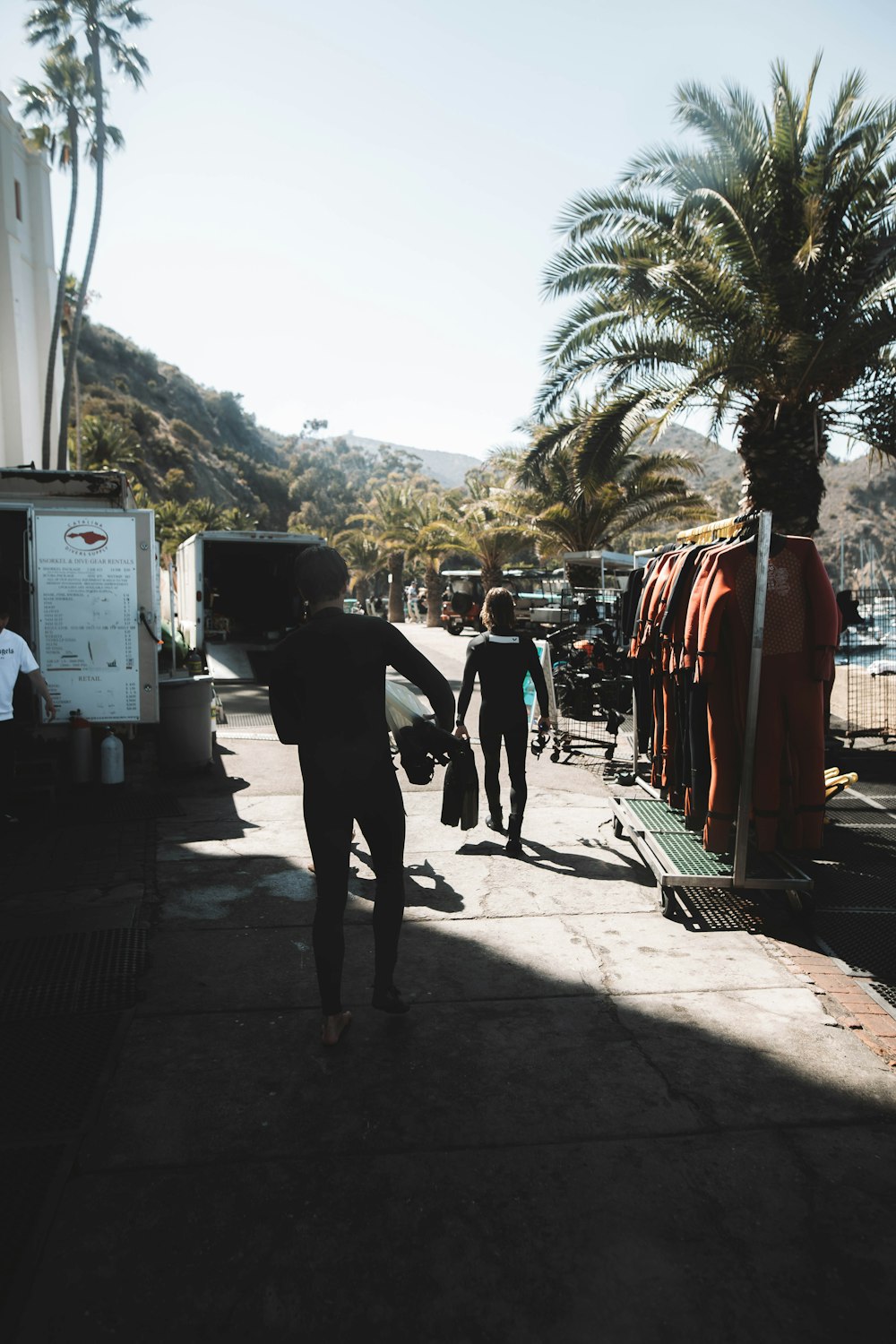 man in black suit walking on sidewalk during daytime