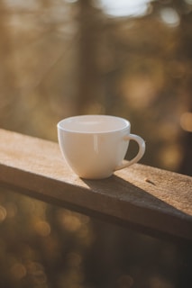 white ceramic mug on brown wooden table