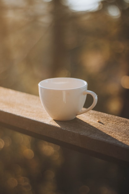 white ceramic mug on brown wooden table